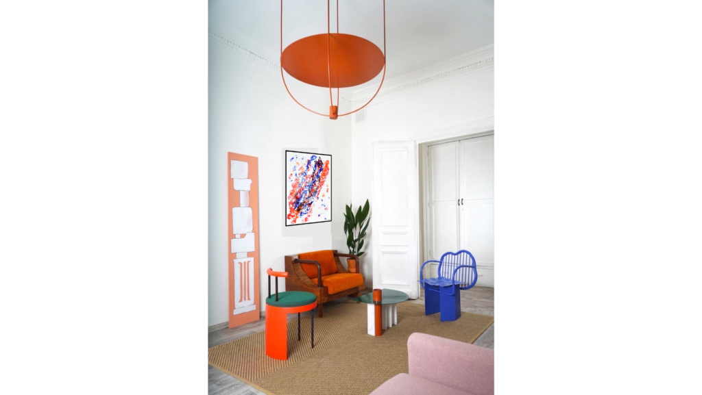 Cuadro llamado "El geni". Tiene 4 colores. Predomina el color blanco de fondo, el color azul eléctrico, el naranja y el rojo dando un toque moderno a la pieza. De entre las distintas formas que aparecen, se puede apreciar la forma de un genio arriba del todo.